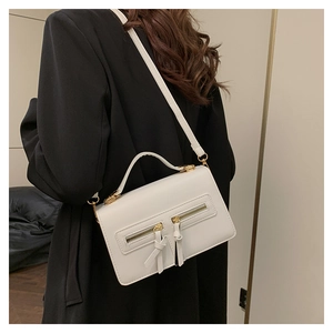Detail of cream white PU leather crossbody bag with dual zippers and gold hardware accents