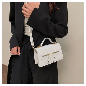 Detail of white leather mini square bag with golden double zippers and crossbody strap