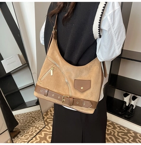Detail of vintage brown suede hobo bag with motorcycle style zippers and belt buckle
