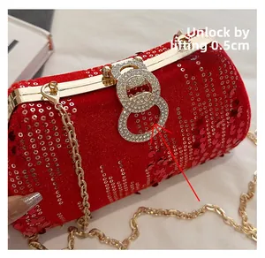 Detail of red sequined clutch with sparkling rhinestone lock and golden chain strap