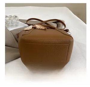 Vue détaillée de la base rectangulaire renforcée d'un sac seau marron caramel grainé