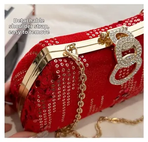 Detail of red velvet evening bag with sequins and gold chain strap close-up view