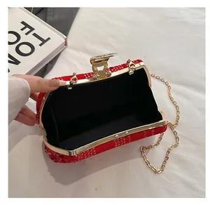 Detail view of the red sequin clutch interior with golden metal frame and chain strap