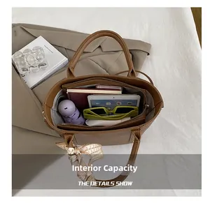 Vue intérieure du sac seau en cuir marron montrant sa grande capacité et ses rangements