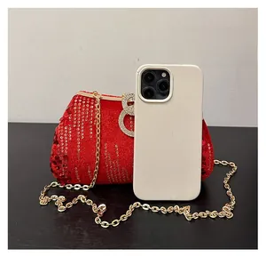 Close-up of red sequined clutch bag with gold chain strap and crystal lock detail