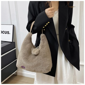 Gros plan détaillé d'un sac à main en peluche marron avec étiquette violette et anse en cuir