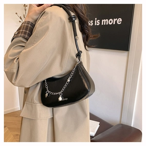 Detail of black crescent hobo bag with silver chain and pearl charms on model