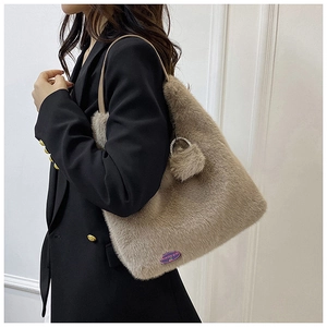 Détail d'un sac à bandoulière en fausse fourrure douce avec anneau métal et pompon