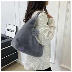 Détail du sac cabas en fausse fourrure grise avec texture douce et bandoulière