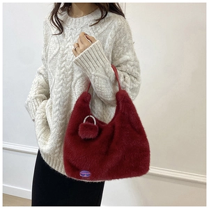 Détail du sac à main rouge en peluche avec étiquette FASHION GIRL et pompon doux