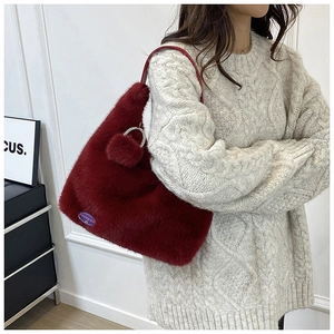 Détail du sac cabas en fausse fourrure bordeaux avec bandoulière et anneau en strass