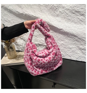 Gros plan détaillé sur la texture en fausse fourrure rose en forme de cœur du sac d'hiver