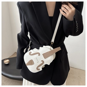 Detail of creative violin-shaped crossbody bag with faux strings and leather stitching