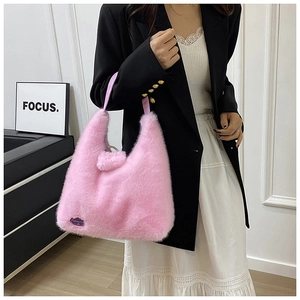 Détail du sac cabas en fausse fourrure rose montrant la texture et l'étiquette tissée