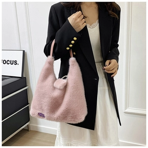 Détail du sac cabas en fausse fourrure rose avec anses en cuir et étiquette violette