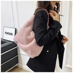Mannequin portant un sac à bandoulière en peluche rose dans un intérieur moderne