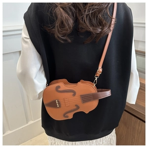Detail view of artistic violin-shaped crossbody bag with contrast stitching and gold rivets