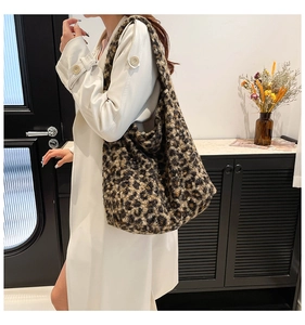 Détail d'un grand sac cabas en peluche léopard montrant sa texture douce et sa bandoulière