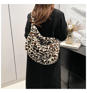 Detail of plush leopard print shoulder bag with soft faux fur texture on black coat