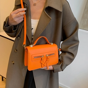 Chic orange crossbody handbag with dual front zippers and tassel detail for women
