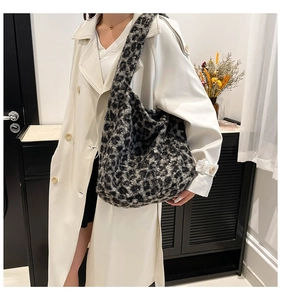 Nahaufnahme der Leoparden-Plüschtasche kombiniert mit einem weißen Mantel an einem Modell
