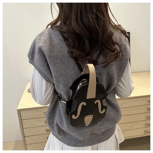 Detail view of the unique violin-shaped backpack with realistic F-holes on a female model