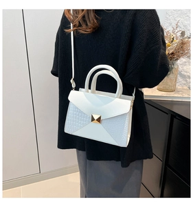 White crocodile pattern patchwork handbag shown as a crossbody bag on a model