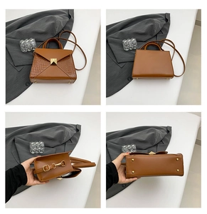 Detail view of crocodile texture splicing and gold protective studs on a brown tote bag