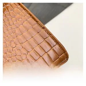 Detail of caramel brown faux leather bag with crocodile texture and fine stitching