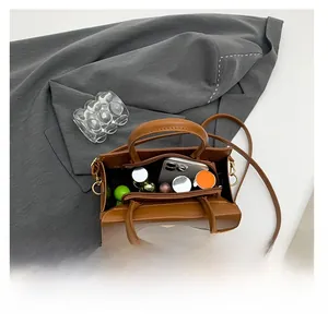Internal view of brown leather square bag showing spacious storage for makeup and phone