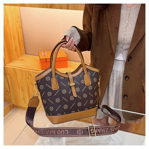 Gros plan d'un sac vintage marron avec monogramme et bandoulière large ajustable