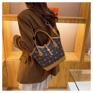 Détail d'un grand sac cabas vintage marron avec bandoulière large et finitions cuir