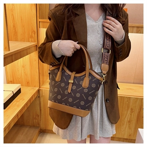 Détail du sac à main vintage monogrammé avec bandoulière jacquard et finitions en cuir brun