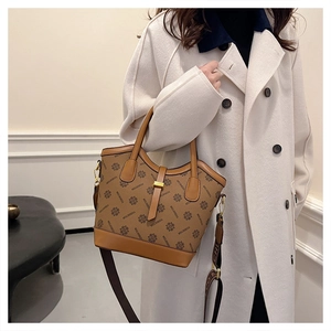 Détails d'un sac cabas vintage avec monogramme, finitions cuir et boucles dorées