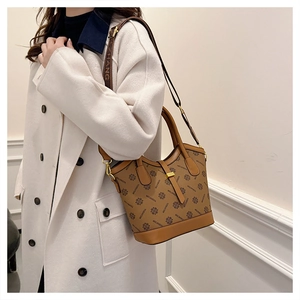 Détail d'un sac seau vintage marron avec monogramme et bandoulière à logo ajustable