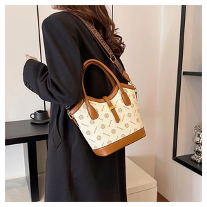 Détail du sac cabas vintage avec logo à motifs et bandoulière en tissu marron