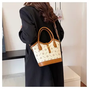 Vue mannequin d'un sac cabas vintage crème avec bordures en cuir marron et motifs imprimés