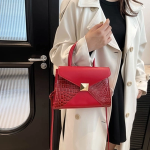 Fashion red crocodile pattern leather handbag with gold buckle shown on a model
