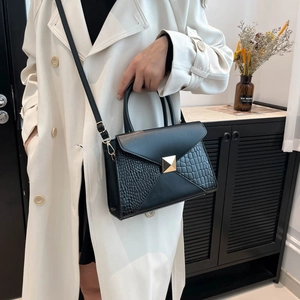 Fashionable crocodile pattern crossbody bag with golden buckle shown on a model