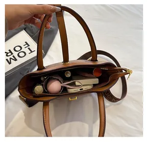 Vue intérieure du sac en cuir marron montrant sa grande capacité pour parapluie et cosmétiques