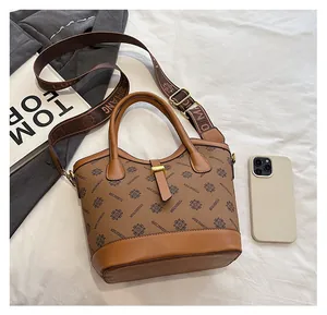 Comparaison de taille détaillée du sac à main marron vintage avec un smartphone