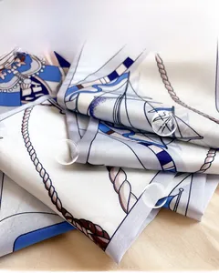 Détail macro d'un foulard en soie nautique avec motifs de cordes et texture soyeuse