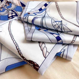Gros plan détaillé d'un foulard en soie aux motifs nautiques de voiliers et cordages