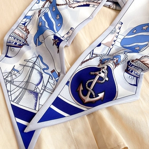 Détail d'un foulard étroit avec motifs nautiques d'ancres et voiliers sur soie blanche