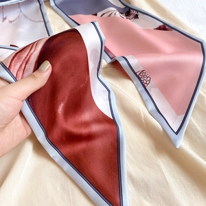 Détail d'un foulard étroit en soie avec motif floral et blocs de couleurs