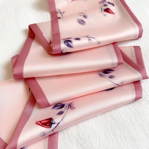 Detail of silk scarf with pink floral print and premium satin texture close-up