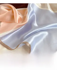 Close-up of machine-rolled edges and silk satin texture of a color-block scarf
