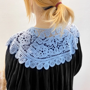 Detailed back view of light blue hollow crochet lace collar on a black pleated blouse