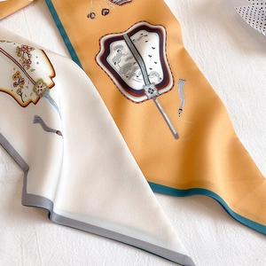 Macro shot of silk scarf detailing traditional fan prints and smooth fabric texture