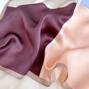 Macro detail of the smooth silk texture and hand-rolled edges on a geometric silk scarf